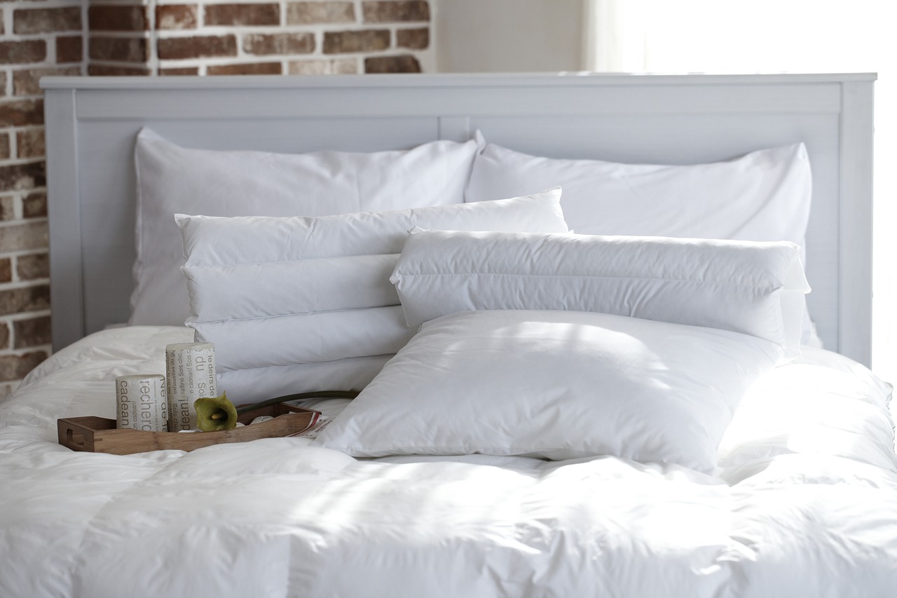 Sypialnia w stylu skandynawskim – białe łóżko podwójne do sypialni.